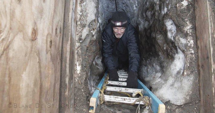 Artist climbing 30 feet down below giant ice wedge, research ice cavern, Utqiagvit, AK